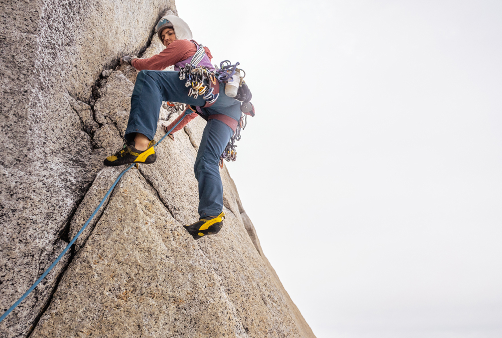 vrouw klimt tegen een rotswand omhoog